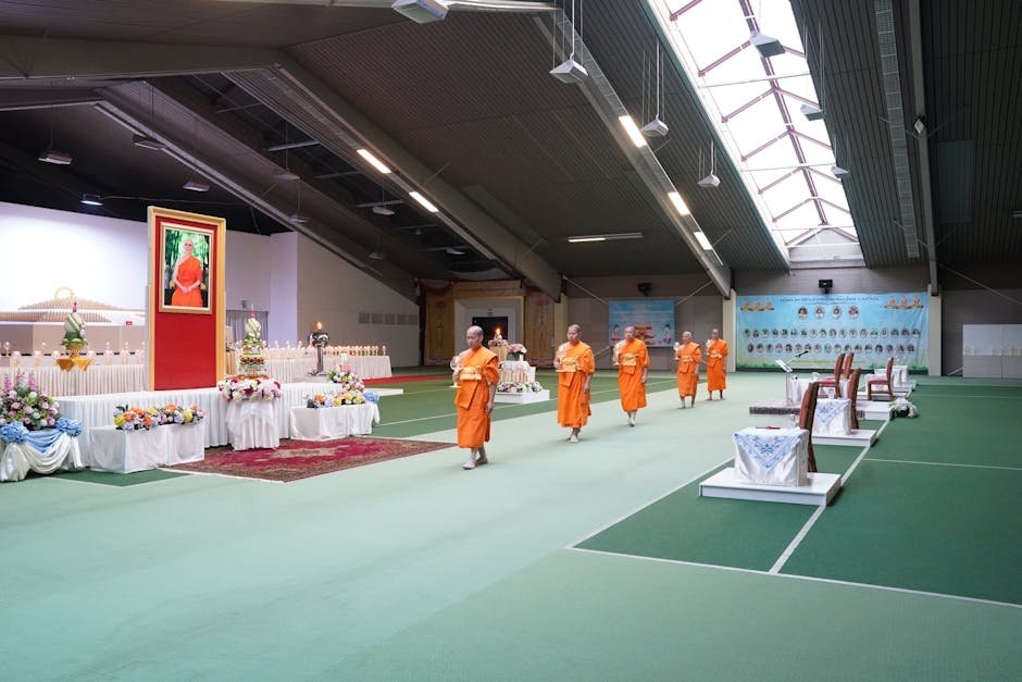Buddhist meditation hall with rows of cushions facing an altar with candles and flowers