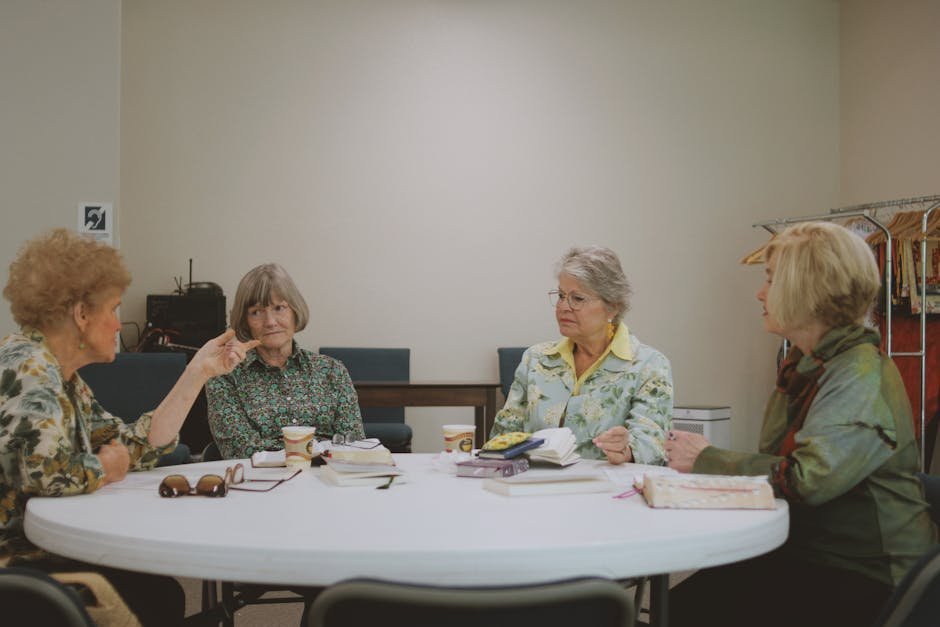 Small group of adults discussing a novel around a wooden table at a library