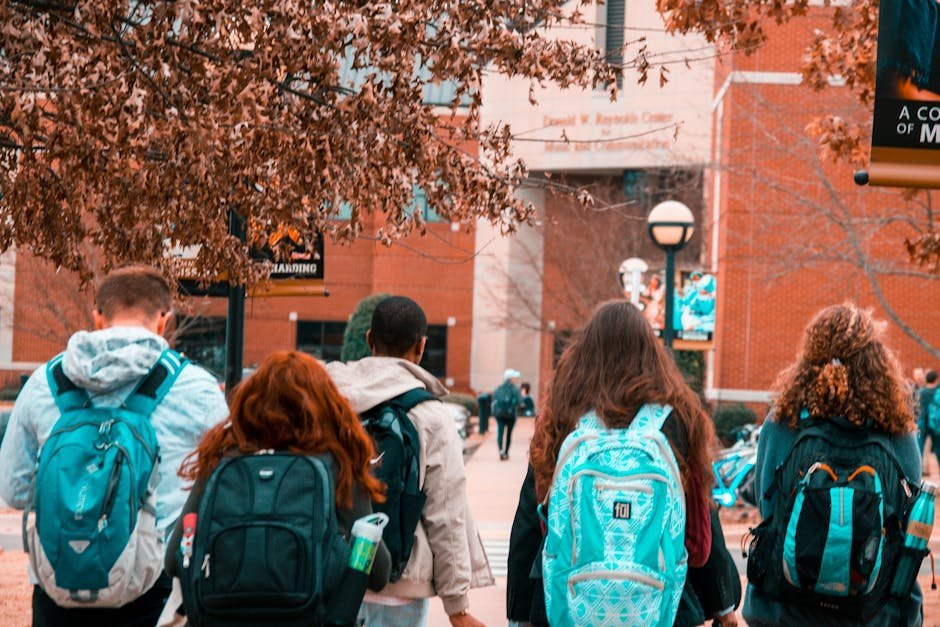 Diverse group of college students walking on campus quad near a wellness center sign