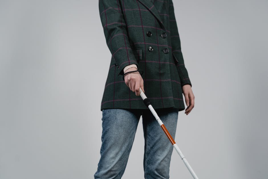 Blind woman with white cane attending audio telehealth therapy session at home