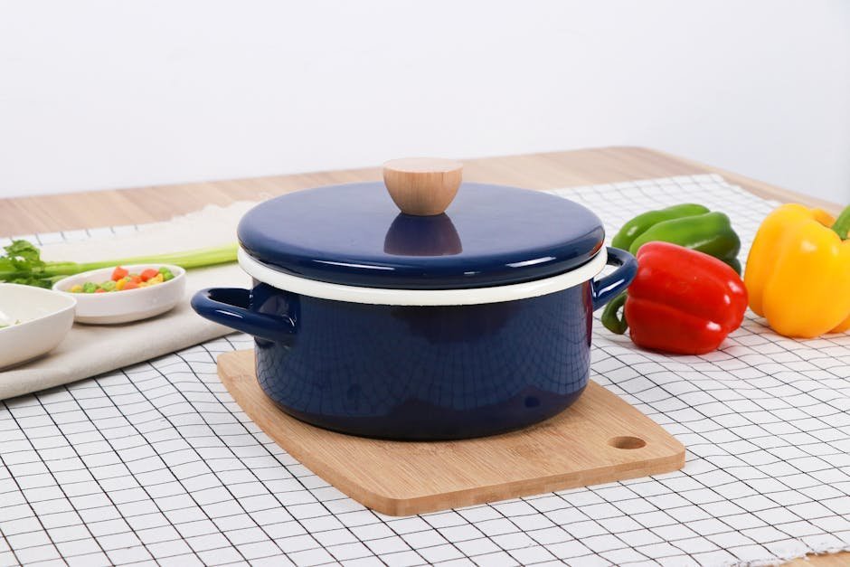 A simple home kitchen with a single pot of soup simmering and basic ingredients on the counter