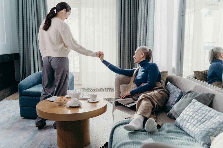 Adult daughter helping elderly mother review Medicare paperwork at kitchen table
