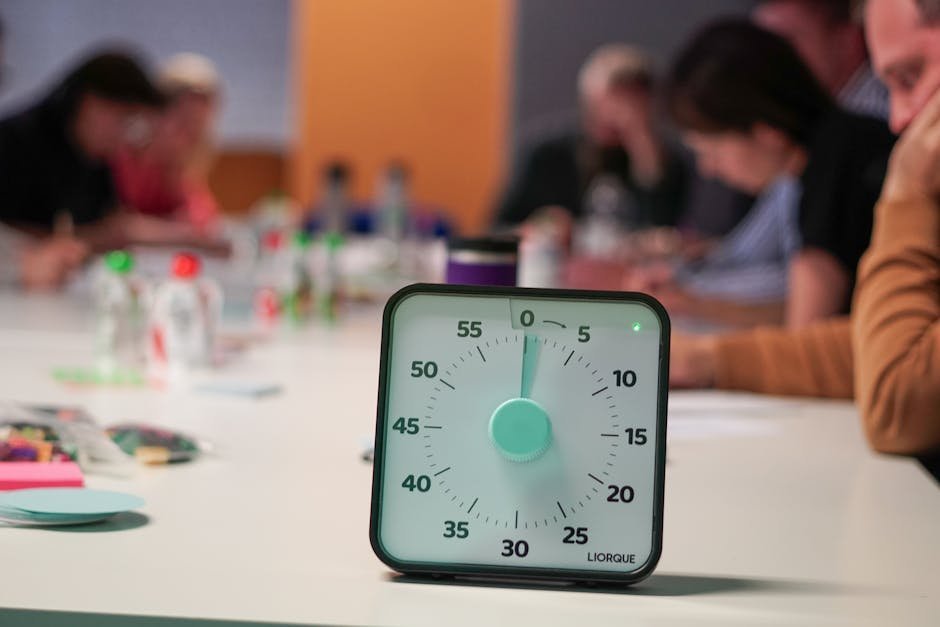 Visual time timer showing red disk draining as the minutes pass on a desk with notebook