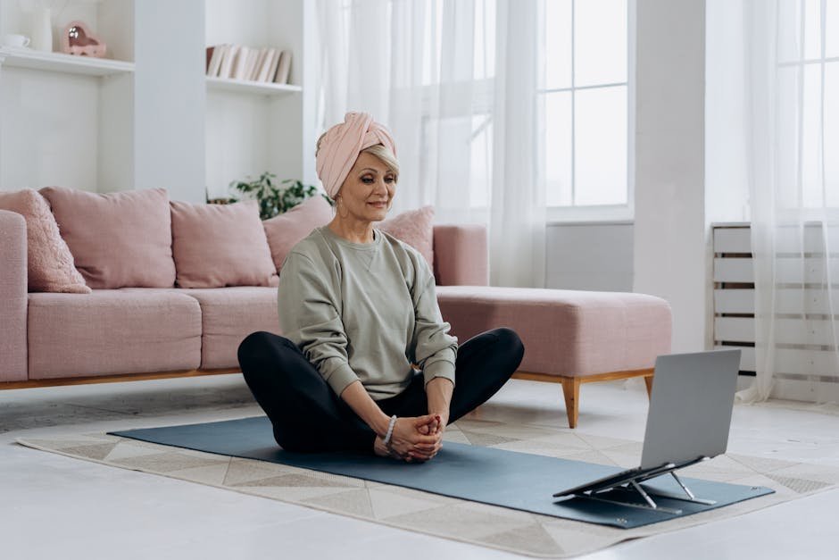 Yoga therapist conducting virtual session with client over video call from home studio