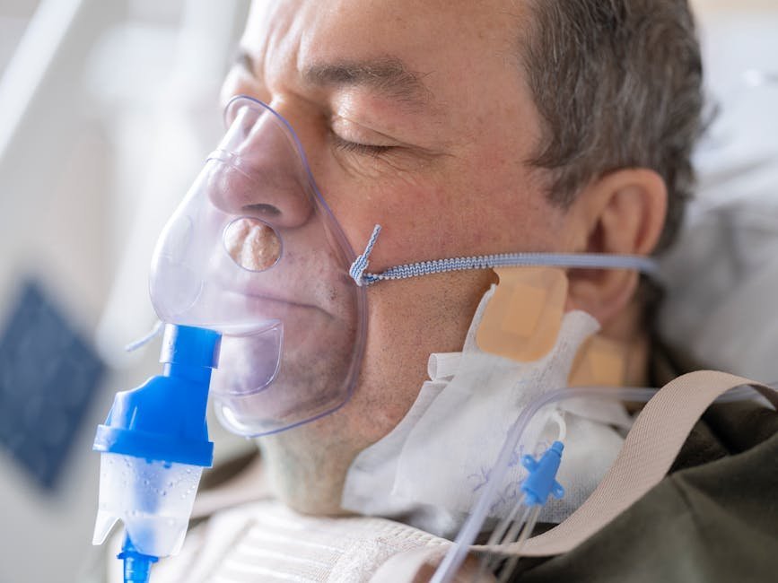 ICU patient sitting up in bed with physical therapist, illustrating early mobility component of ABCDEF bundle