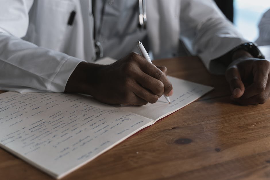 Stack of medical records and ASAM criteria binder on wooden desk