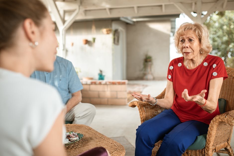 Adult daughter and her elderly mother sitting on a porch swing in late afternoon