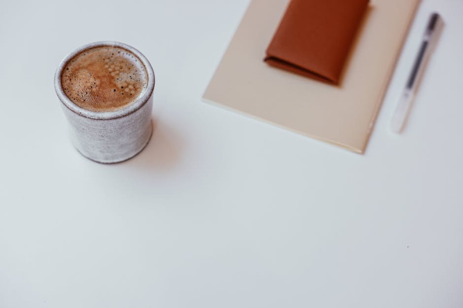 Notebook and a cup of coffee on a small table inside a treatment programme common area