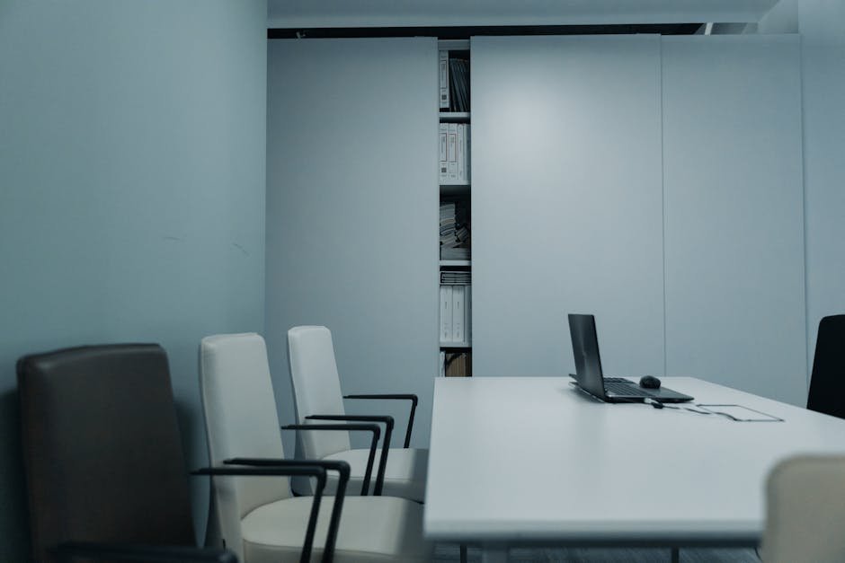 Empty interview room with a table and two chairs by a barred window