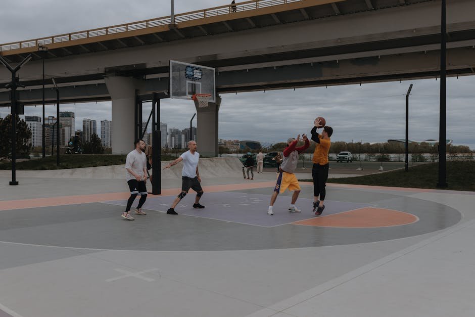 Group of adults playing pickup basketball at neighborhood park during golden hour, social sports league