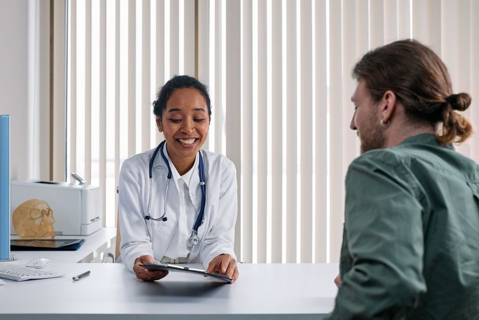 A friendly conversation between a clinician and patient in a bright office, the setting where ADHD medication management happens